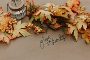 Fall leaves on a table next to a candle